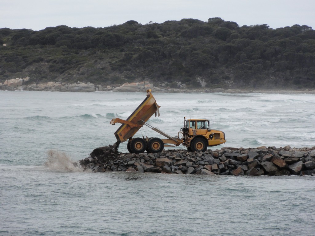 Dump truck off loads stone